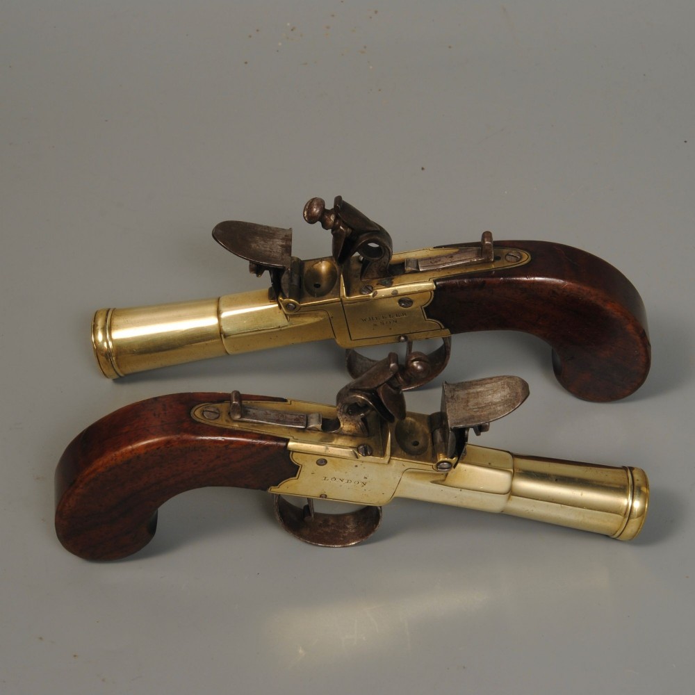 A pair of antique Georgian boxlock flintlock pistols featuring flared brass barrels, steel mechanisms, and dark wood grips. View III