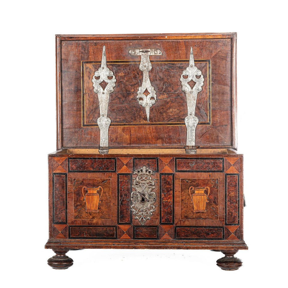A late 17th-century Continental burr wood casket with a stepped lid, inlaid urn motifs, side iron handles, and a decorative keyhole escutcheon resting on bun feet. View V