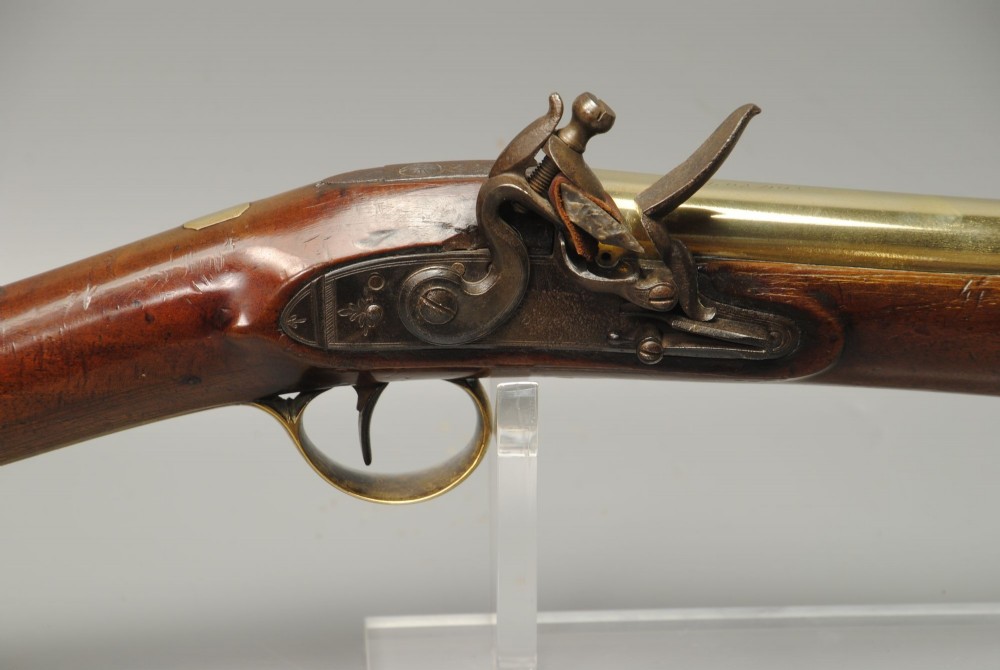 A Georgian flintlock blunderbuss featuring a flared brass barrel, steel lock plate, and polished walnut wooden stock. View II
