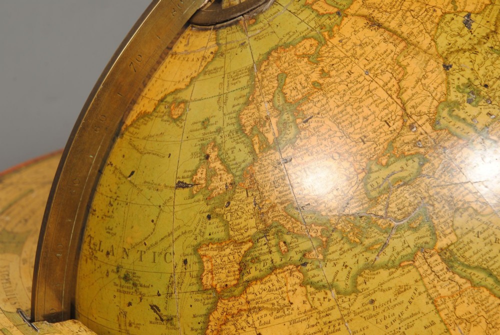 An early nineteenth-century terrestrial table globe supported by a turned mahogany tripod stand with a brass meridian ring and an integrated base compass. View IV