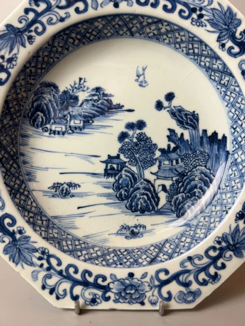 fig 1. A late 18th-century Chinese export porcelain plate featuring hand-painted cobalt blue river landscapes, pagodas, and a patterned border on a white background.
