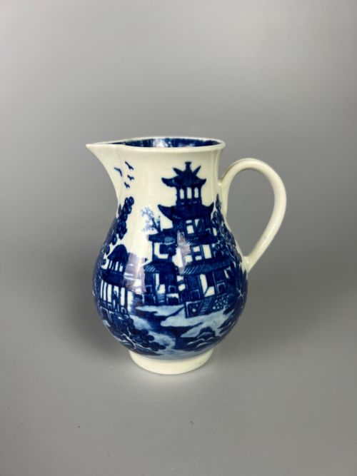 fig 1. An 18th-century Worcester soft-paste porcelain sparrowbeak jug decorated with a blue and white chinoiserie Bandstand pattern.