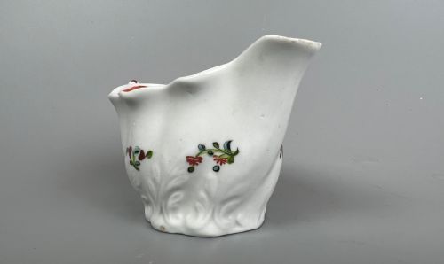 fig 1. An 18th-century white soft-paste porcelain low Chelsea ewer decorated with hand-painted floral sprigs and leaf moulding.