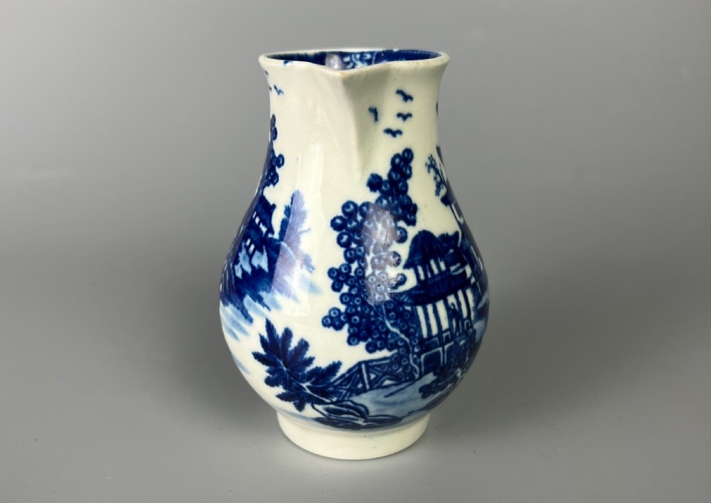 An 18th-century Worcester soft-paste porcelain sparrowbeak jug decorated with a blue and white chinoiserie Bandstand pattern. View III