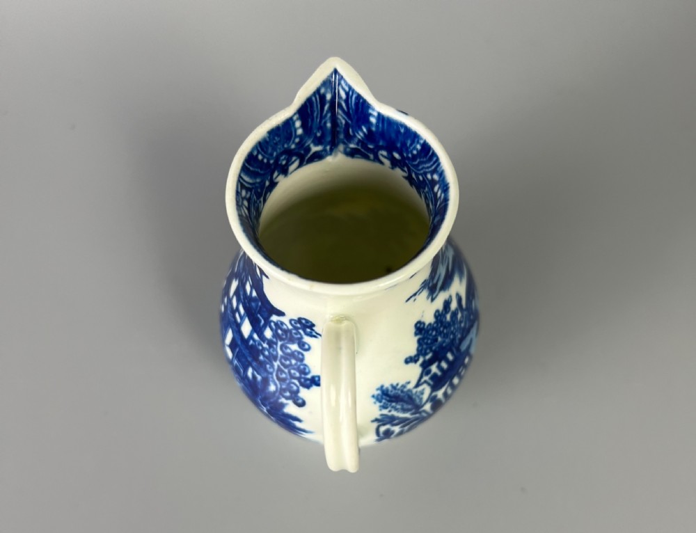 An 18th-century Worcester soft-paste porcelain sparrowbeak jug decorated with a blue and white chinoiserie Bandstand pattern. View V
