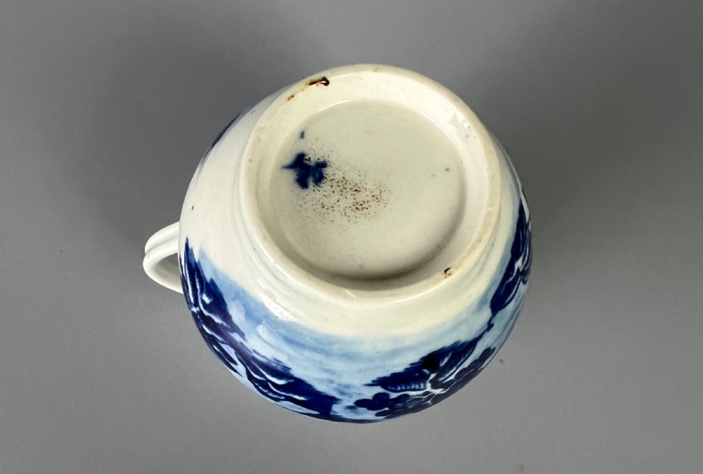 An 18th-century Worcester soft-paste porcelain sparrowbeak jug decorated with a blue and white chinoiserie Bandstand pattern. View VI