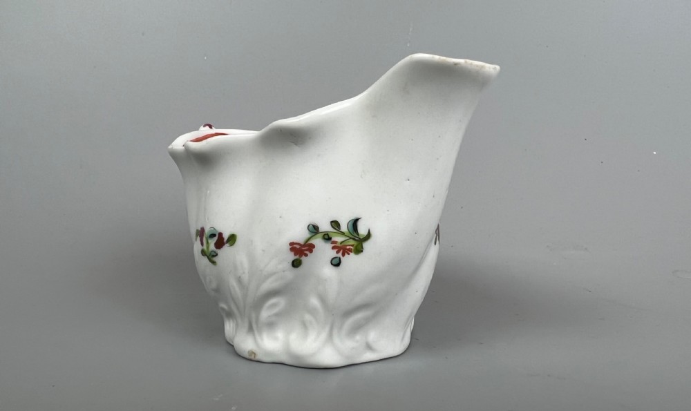 An 18th-century white soft-paste porcelain low Chelsea ewer decorated with hand-painted floral sprigs and leaf moulding. View II