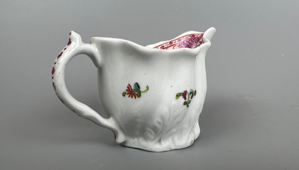 An 18th-century white soft-paste porcelain low Chelsea ewer decorated with hand-painted floral sprigs and leaf moulding. View IV