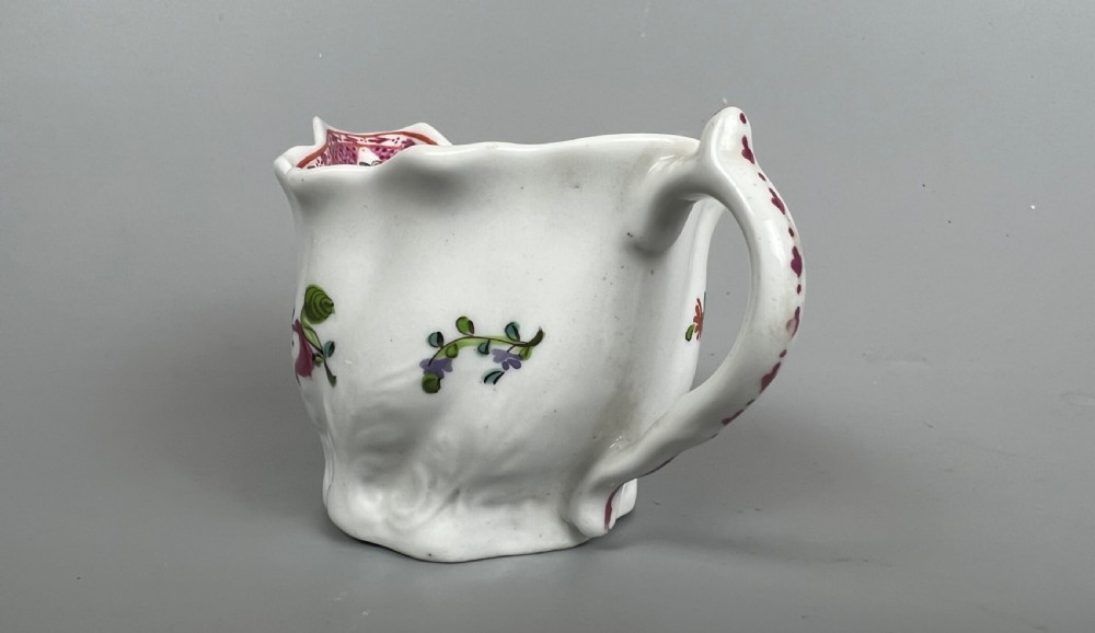 An 18th-century white soft-paste porcelain low Chelsea ewer decorated with hand-painted floral sprigs and leaf moulding. View VII