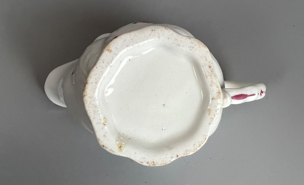 An 18th-century white soft-paste porcelain low Chelsea ewer decorated with hand-painted floral sprigs and leaf moulding. View VIII