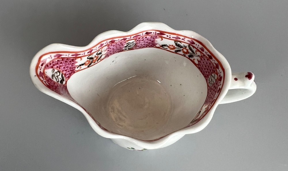 An 18th-century white soft-paste porcelain low Chelsea ewer decorated with hand-painted floral sprigs and leaf moulding. View IX