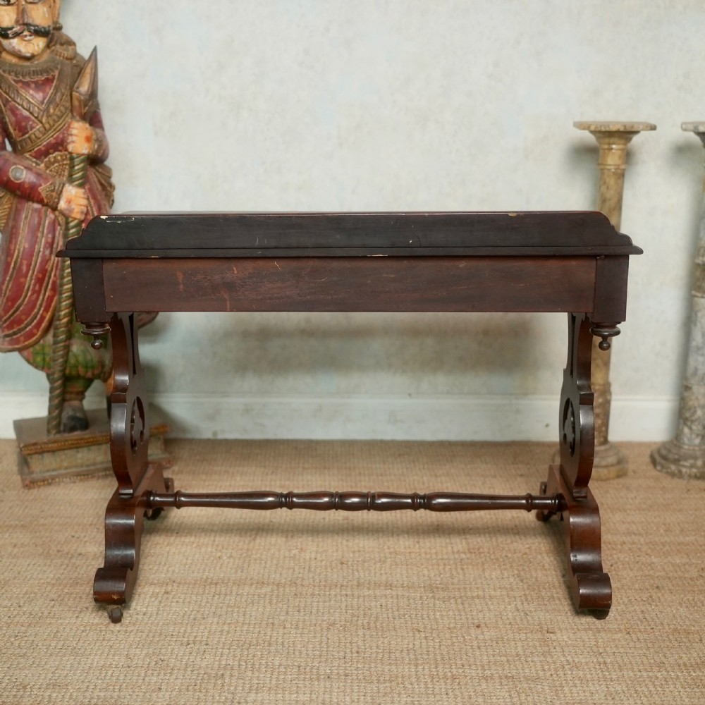 Victorian mahogany writing table with a low rear gallery, turned stretcher, and shaped trestle end supports on castors. View VII