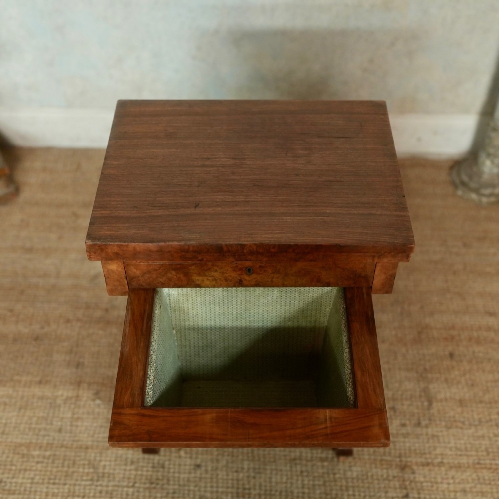 A nineteenth-century rosewood games table featuring a swivel folding top with inlaid chess and backgammon boards, resting on turned trestle supports with a fabric sewing basket underneath. View IX