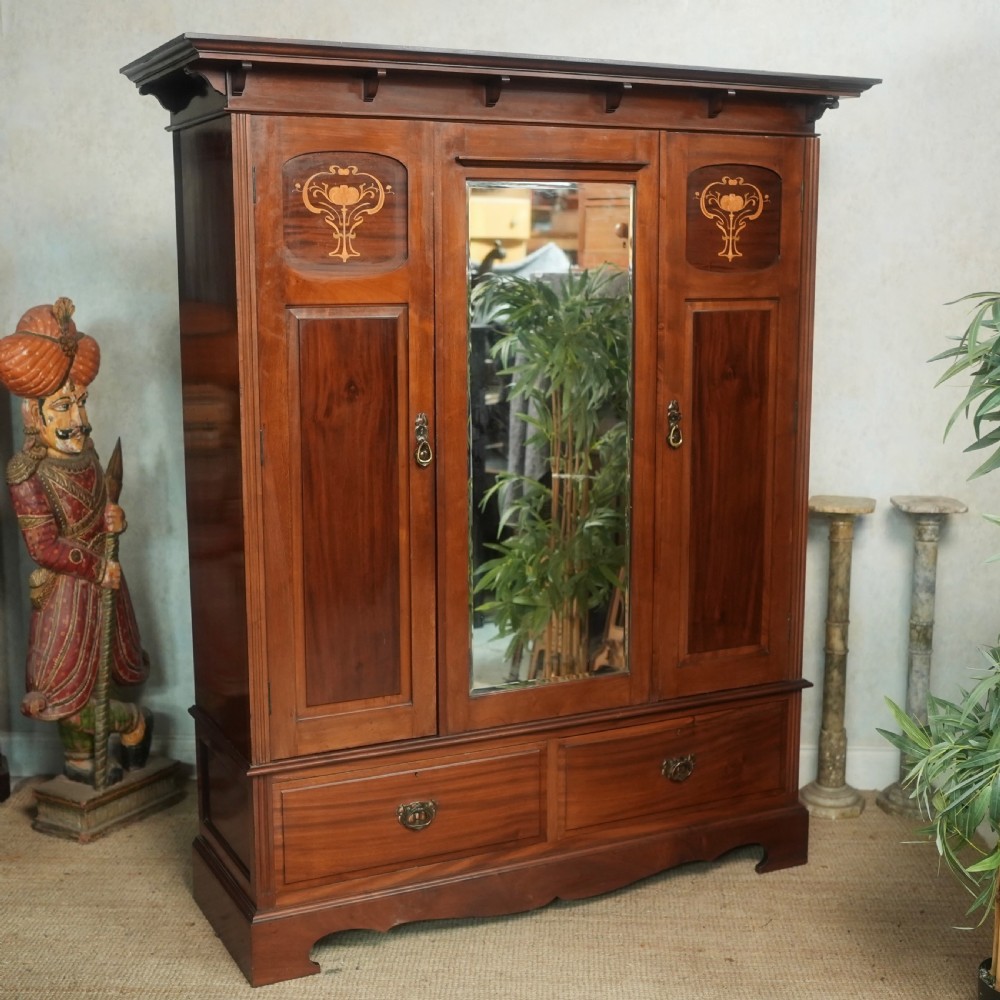 An Edwardian mahogany wardrobe featuring a central full-length mirror door flanked by inlaid timber doors over two lower drawers. View VIII
