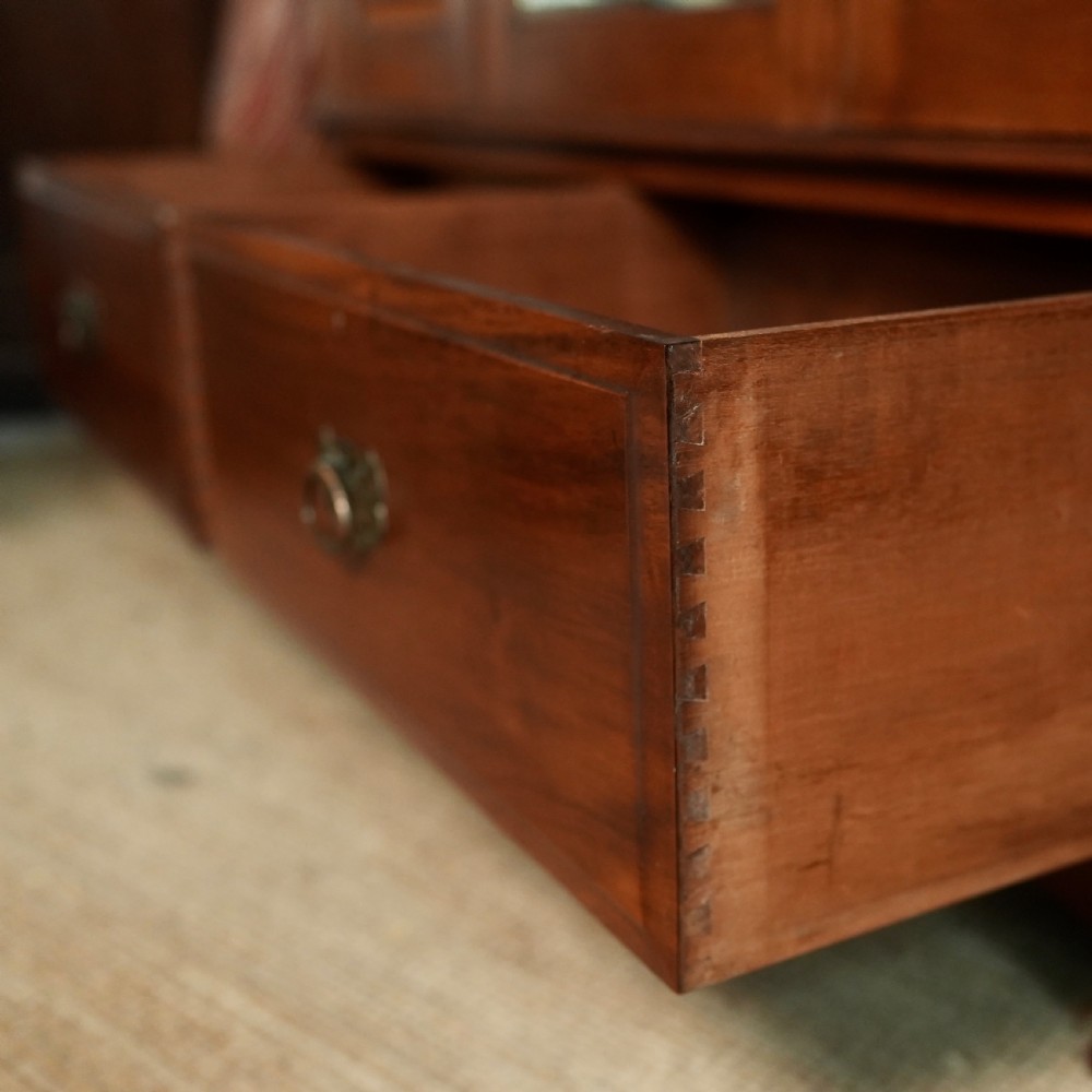 An Edwardian mahogany wardrobe featuring a central full-length mirror door flanked by inlaid timber doors over two lower drawers. View XII