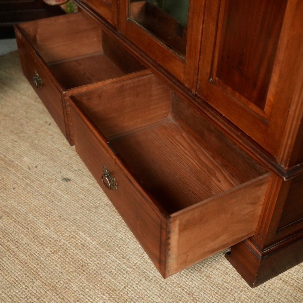 An Edwardian mahogany wardrobe featuring a central full-length mirror door flanked by inlaid timber doors over two lower drawers. View XIII