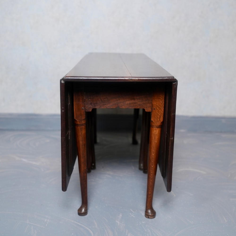 An 18th-century oak gateleg dining table featuring drop-leaf flaps supported by swinging legs terminating in pad feet. View II