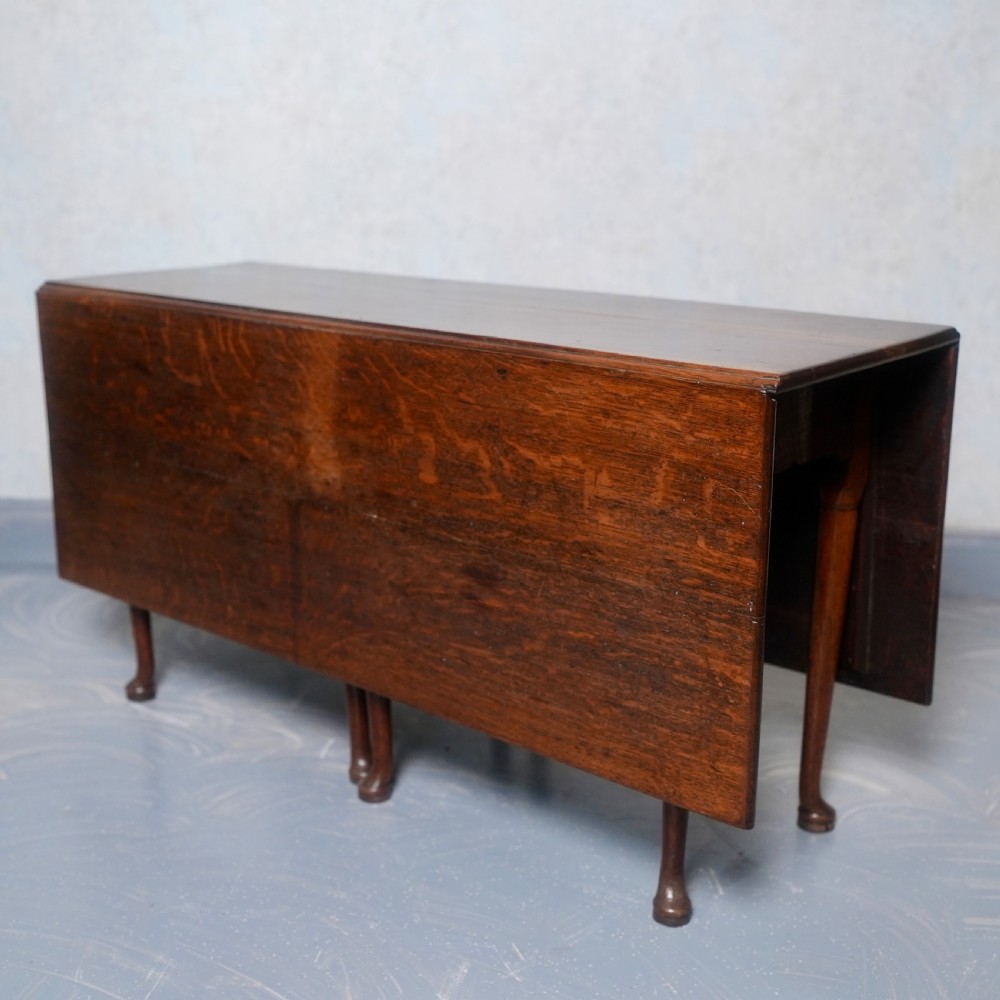 An 18th-century oak gateleg dining table featuring drop-leaf flaps supported by swinging legs terminating in pad feet. View III
