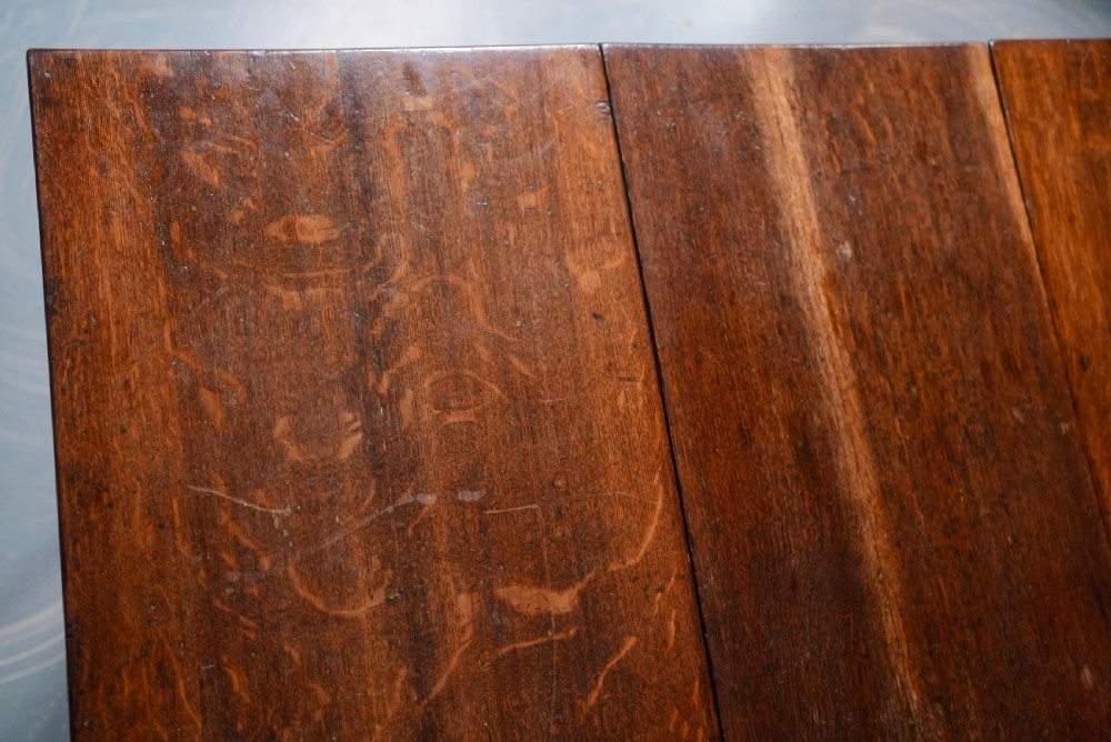 An 18th-century oak gateleg dining table featuring drop-leaf flaps supported by swinging legs terminating in pad feet. View VII