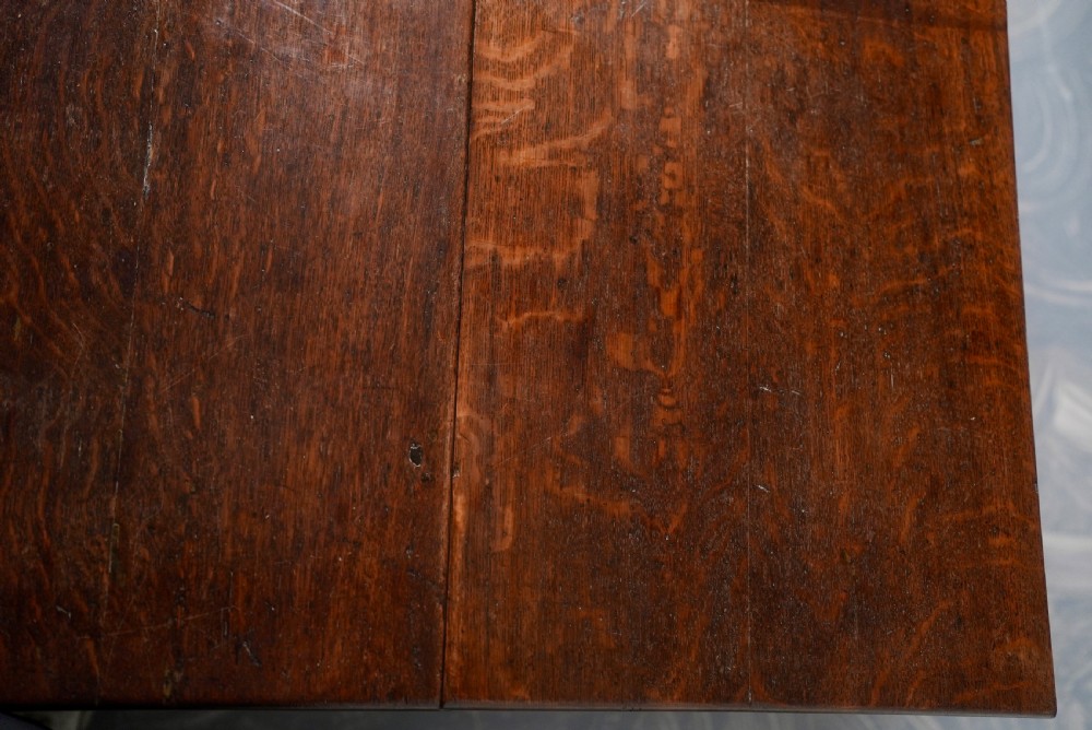 An 18th-century oak gateleg dining table featuring drop-leaf flaps supported by swinging legs terminating in pad feet. View VIII