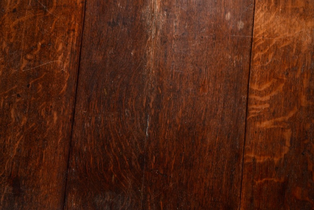 An 18th-century oak gateleg dining table featuring drop-leaf flaps supported by swinging legs terminating in pad feet. View X