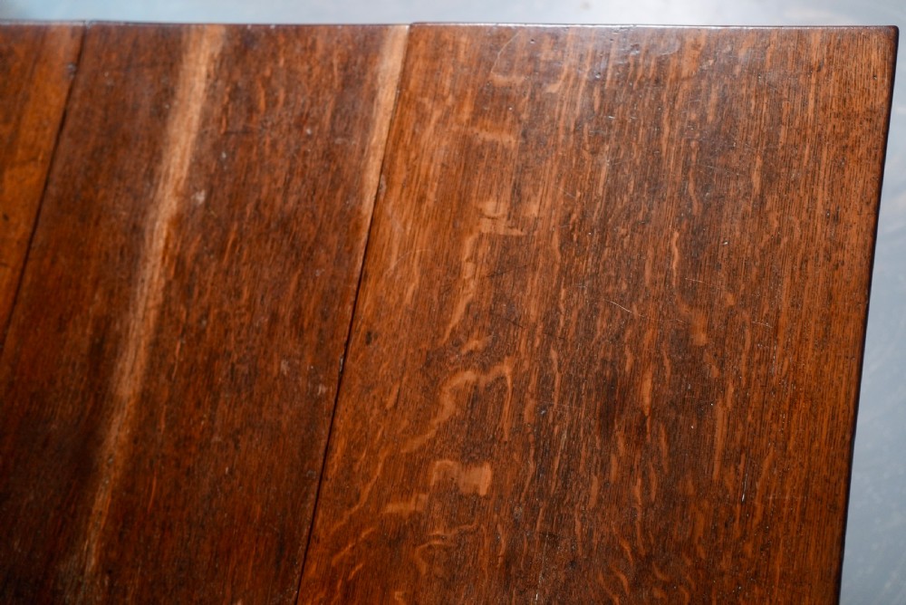 An 18th-century oak gateleg dining table featuring drop-leaf flaps supported by swinging legs terminating in pad feet. View XI