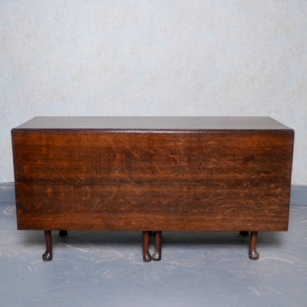 An 18th-century oak gateleg dining table featuring drop-leaf flaps supported by swinging legs terminating in pad feet. View XIV