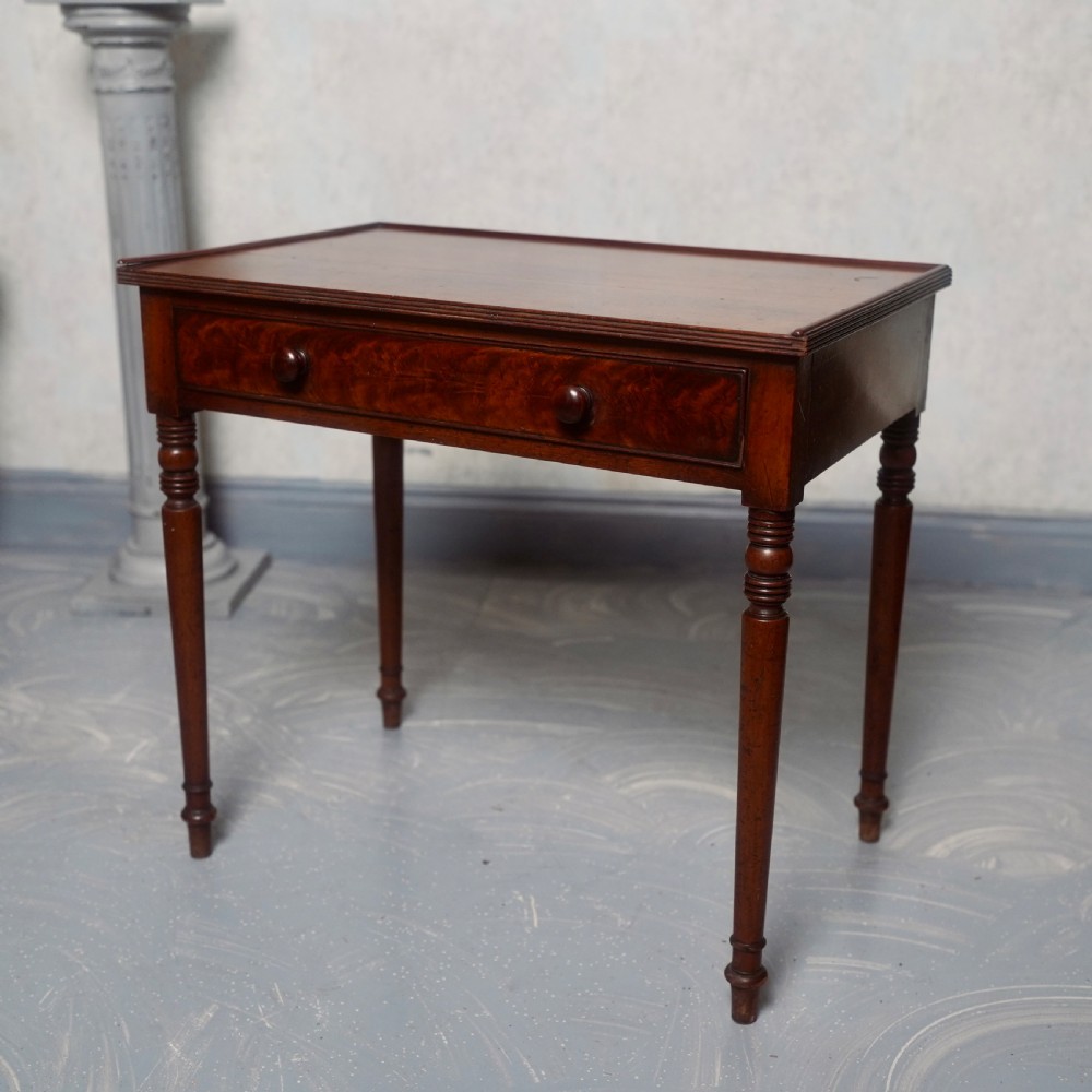 A 19th-century mahogany writing table featuring a single long drawer with turned wooden knobs and slender turned legs.