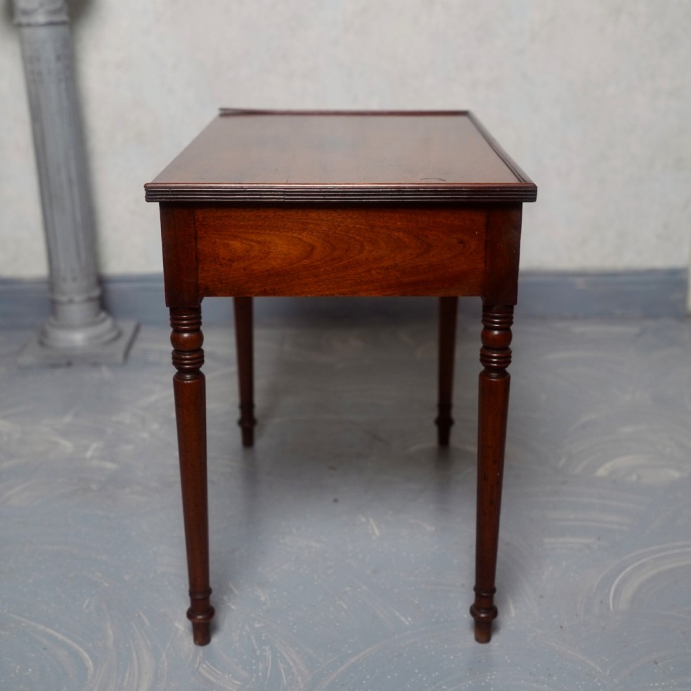 A 19th-century mahogany writing table featuring a single long drawer with turned wooden knobs and slender turned legs. View V