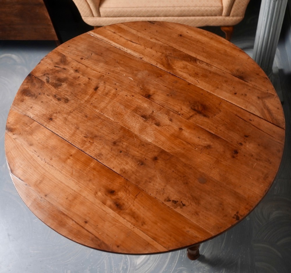 An antique French fruitwood drop-leaf dining table with turned legs, castors, and a warm honey-toned wood grain. View VIII