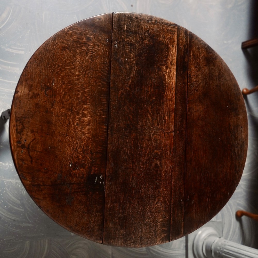 An eighteenth-century dark oak gateleg table shown with drop-leaf sides folded down, featuring turned legs and lower stretchers. View IX