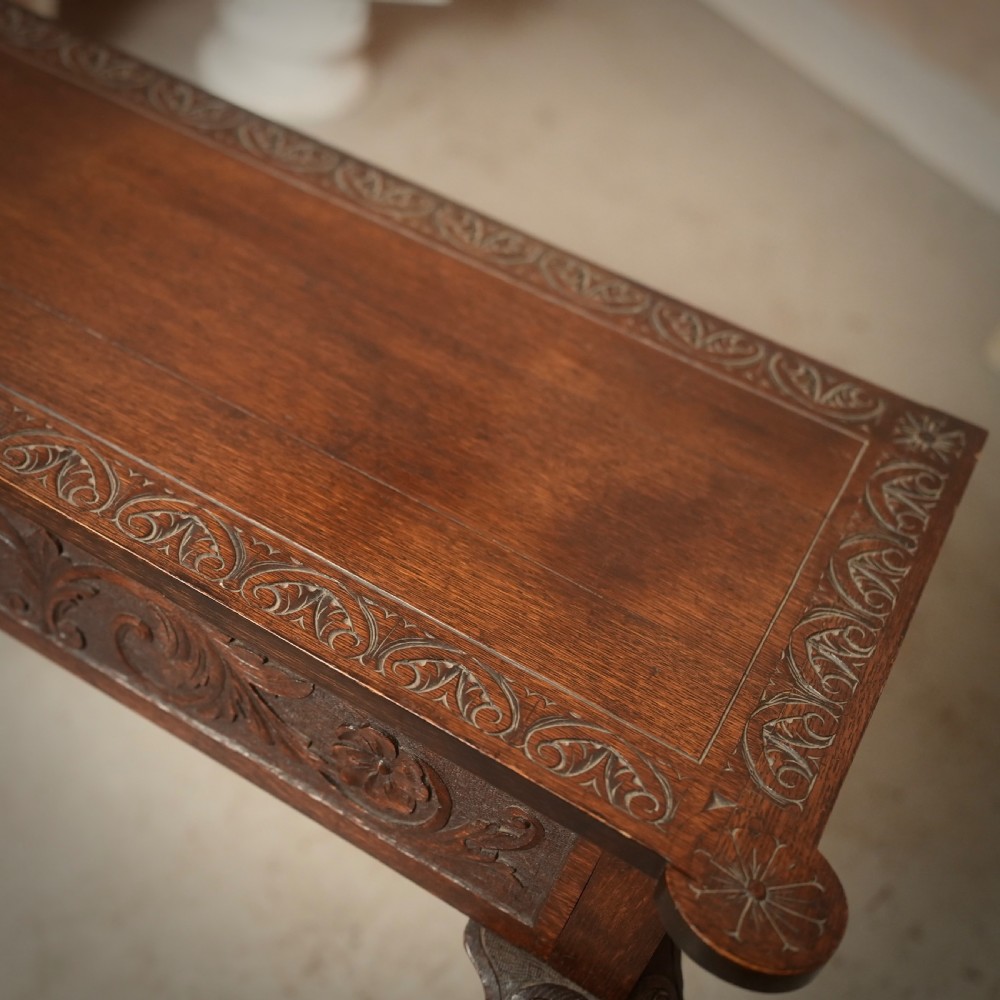 An 18th-century Irish dark oak writing table featuring a hand-carved floral apron and slender cabriole legs. View VI