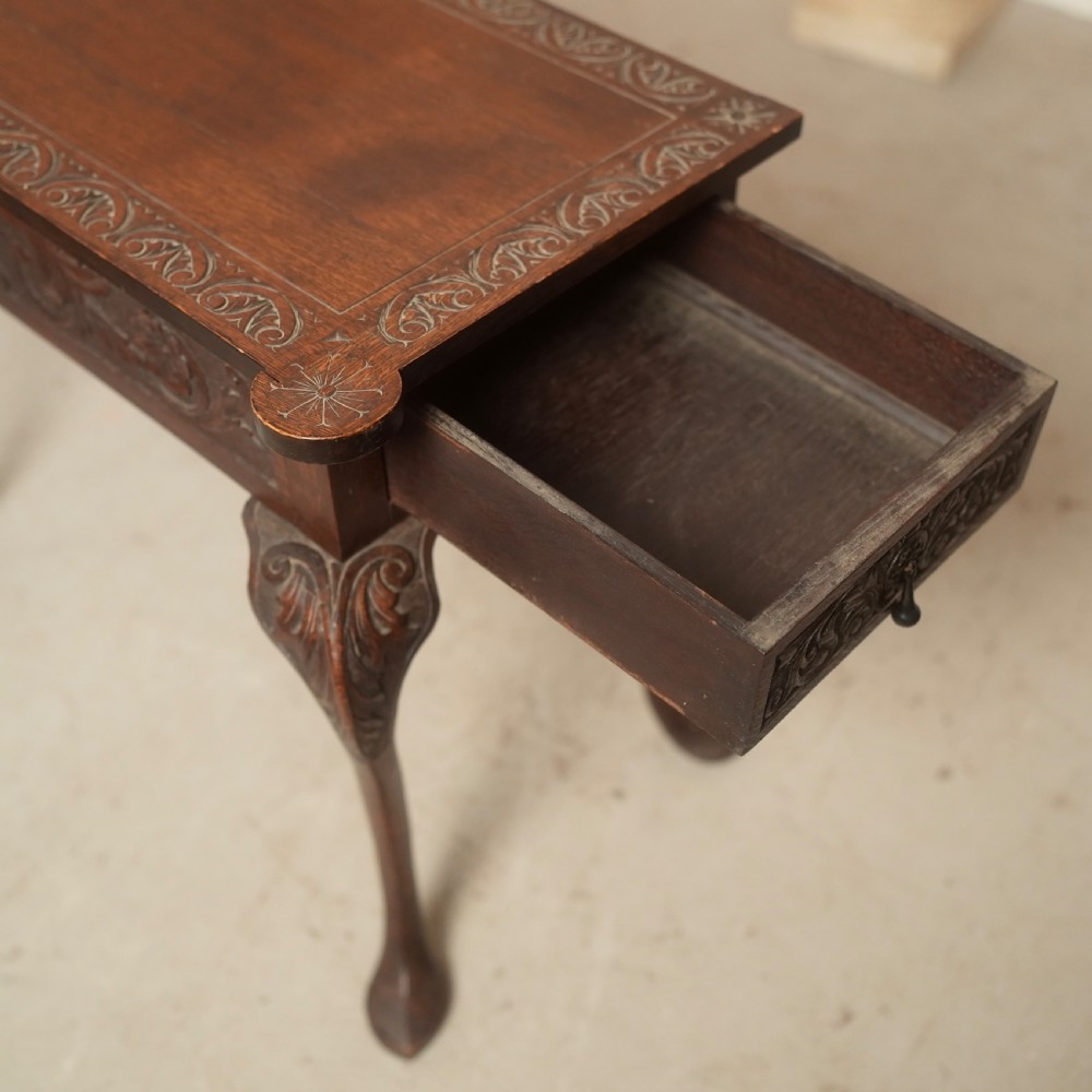 An 18th-century Irish dark oak writing table featuring a hand-carved floral apron and slender cabriole legs. View VIII