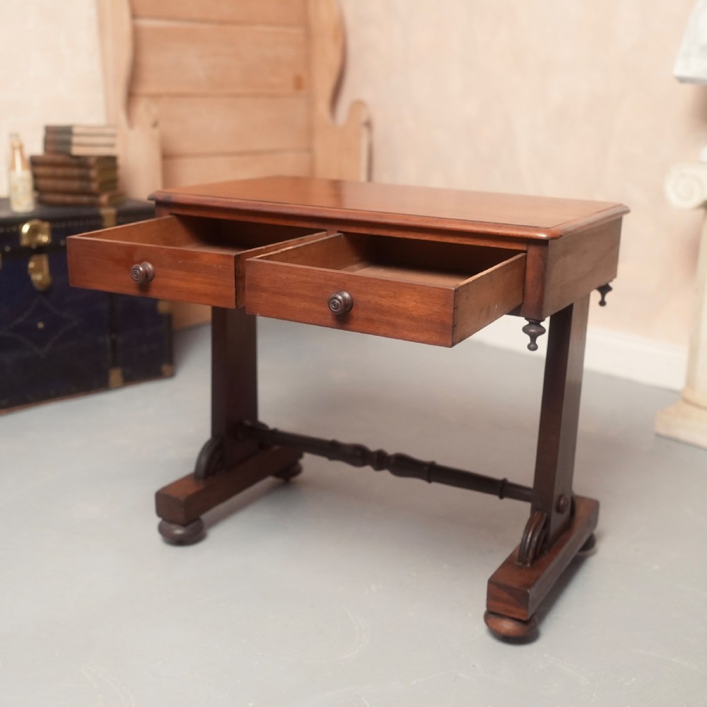 A 19th-century mahogany writing table with two drawer fronts, turned wooden knobs, corner pendants, and a turned central stretcher between trestle legs. View III
