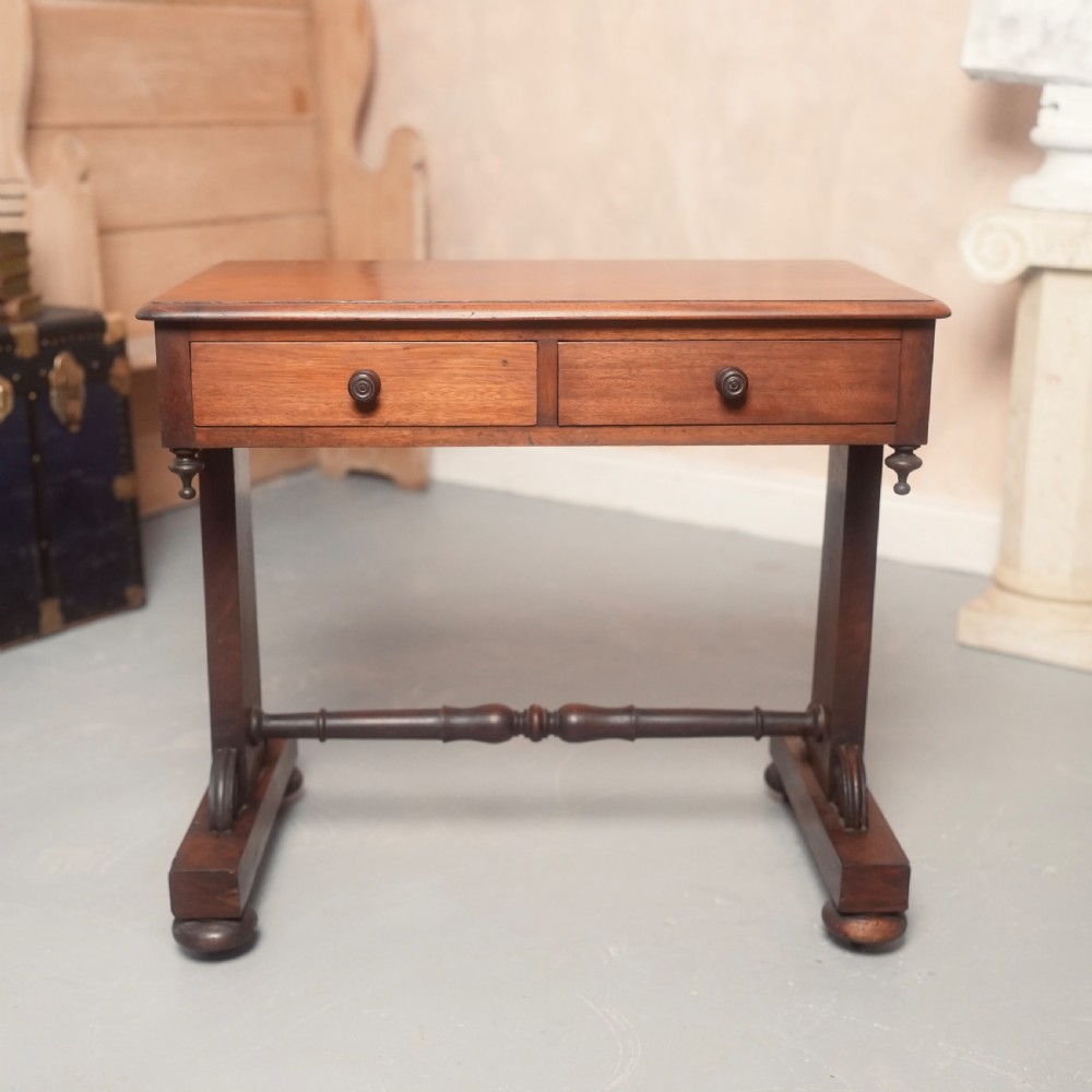 A 19th-century mahogany writing table with two drawer fronts, turned wooden knobs, corner pendants, and a turned central stretcher between trestle legs. View VI