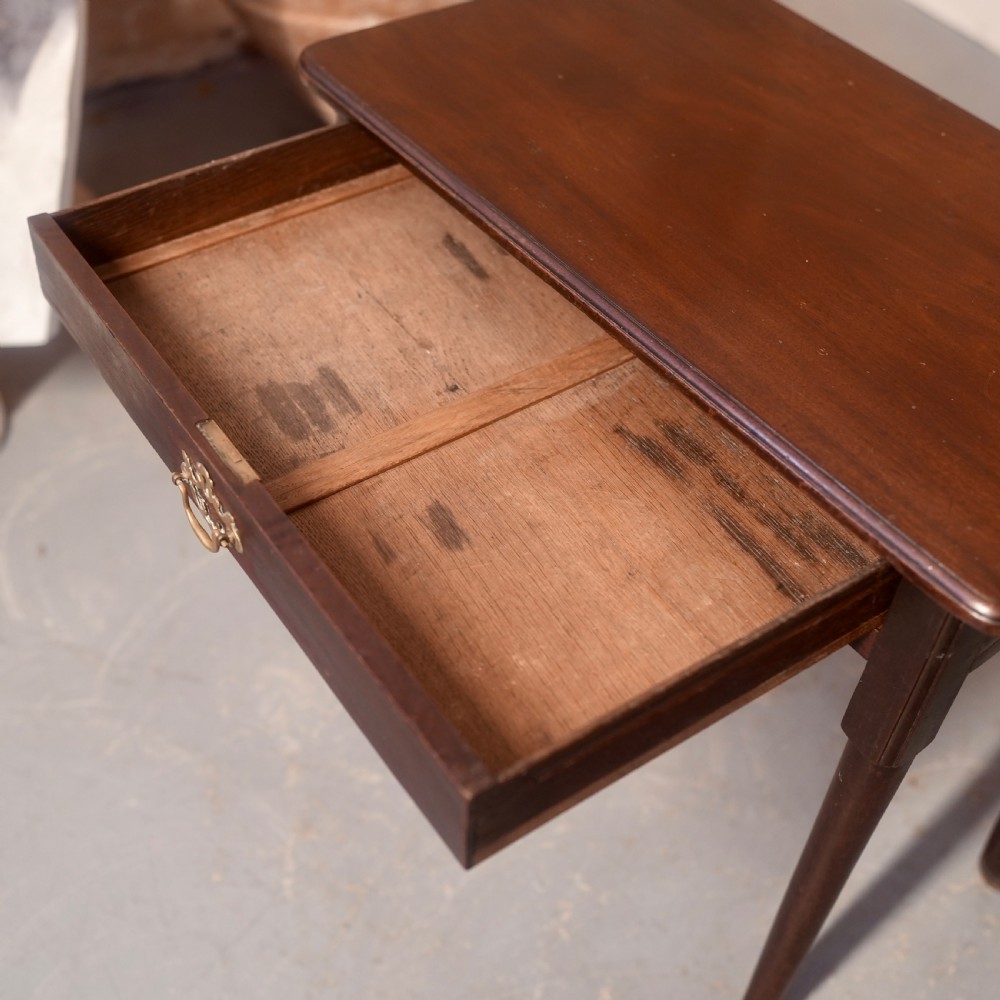 An 18th-century dark mahogany writing table featuring a single drawer with a brass handle plate and slender legs. View VI