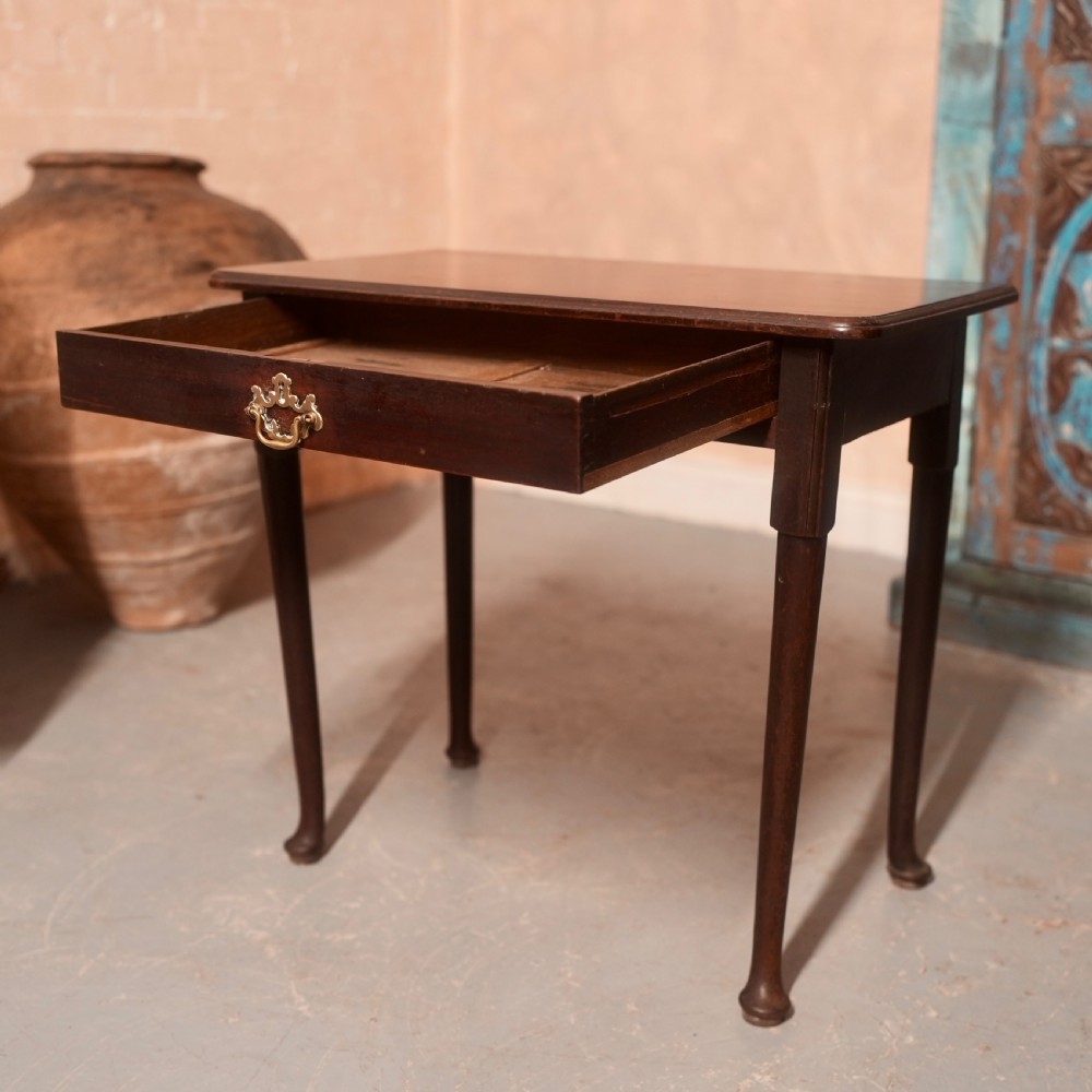 An 18th-century dark mahogany writing table featuring a single drawer with a brass handle plate and slender legs. View VII