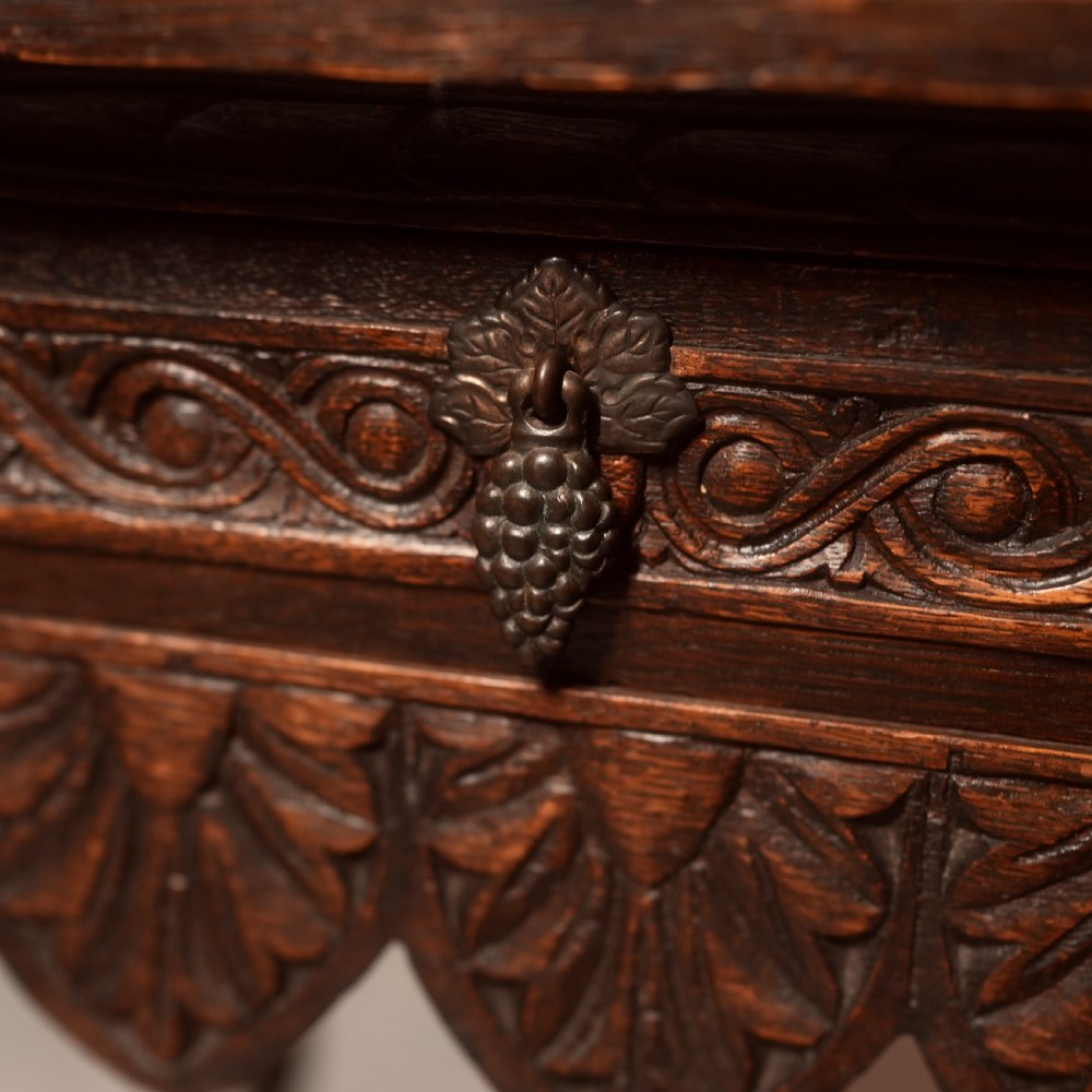 A 19th-century dark carved oak writing table featuring barley twist legs, a scalloped apron frieze, and twin drawers with ornate metal pulls. View IV