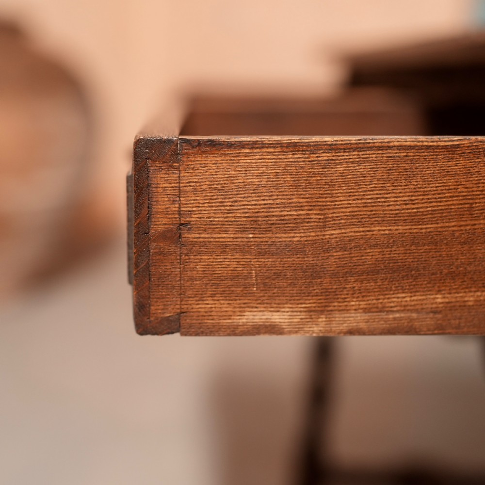 A 19th-century dark carved oak writing table featuring barley twist legs, a scalloped apron frieze, and twin drawers with ornate metal pulls. View VII