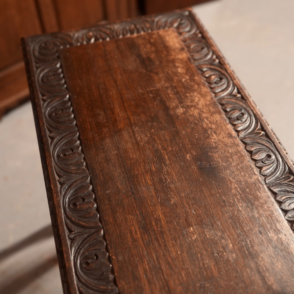 A 19th-century dark carved oak writing table featuring barley twist legs, a scalloped apron frieze, and twin drawers with ornate metal pulls. View X