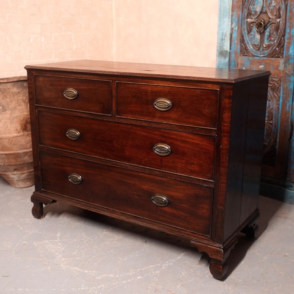 An 18th-century Georgian mahogany chest of drawers featuring two short over two long drawers, oval brass handles, and bracket feet. View IV