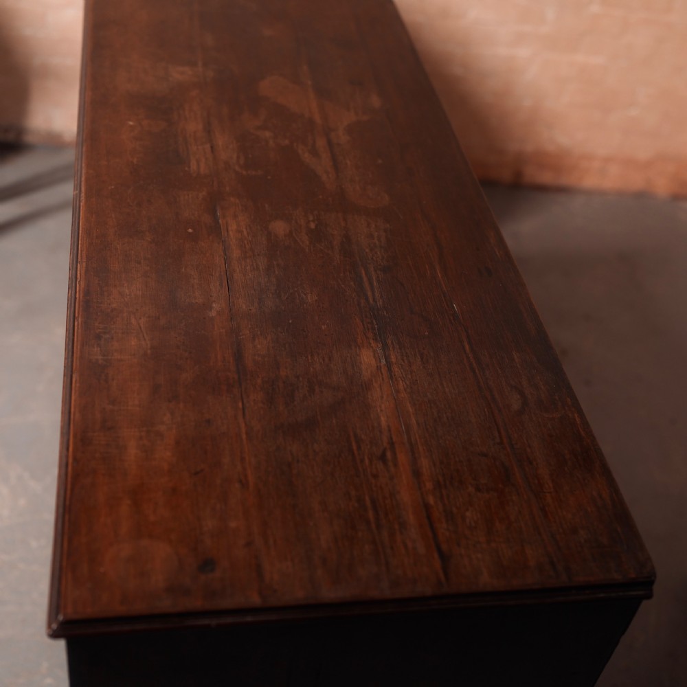 An 18th-century Georgian mahogany chest of drawers featuring two short over two long drawers, oval brass handles, and bracket feet. View V