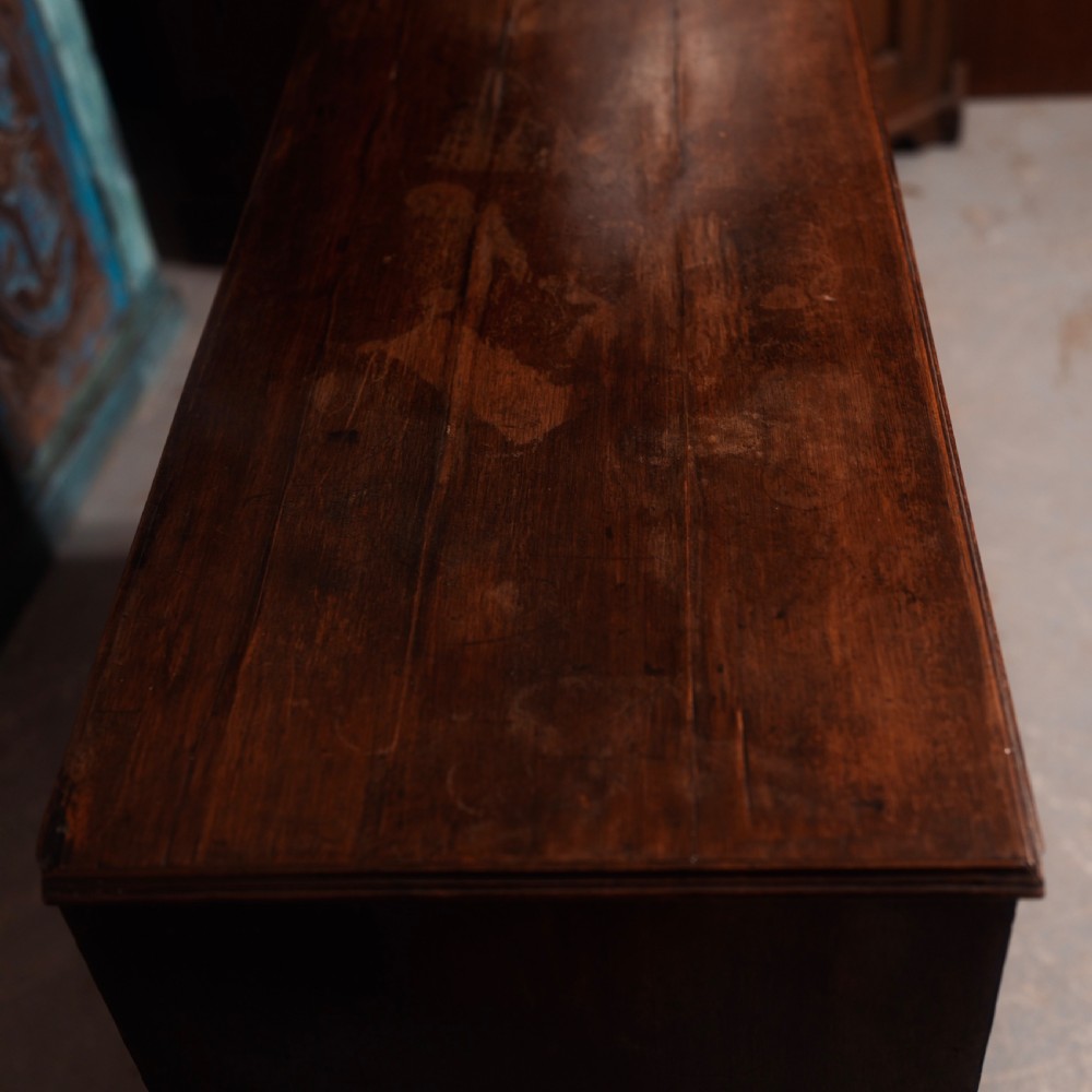 An 18th-century Georgian mahogany chest of drawers featuring two short over two long drawers, oval brass handles, and bracket feet. View VI