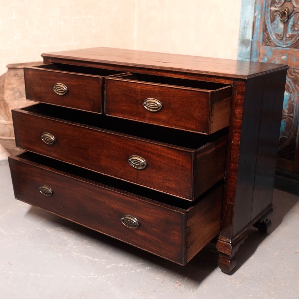 An 18th-century Georgian mahogany chest of drawers featuring two short over two long drawers, oval brass handles, and bracket feet. View VII