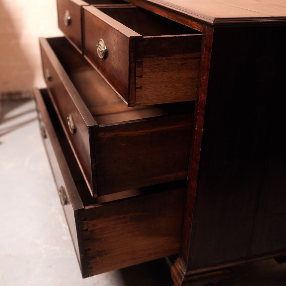 An 18th-century Georgian mahogany chest of drawers featuring two short over two long drawers, oval brass handles, and bracket feet. View VIII