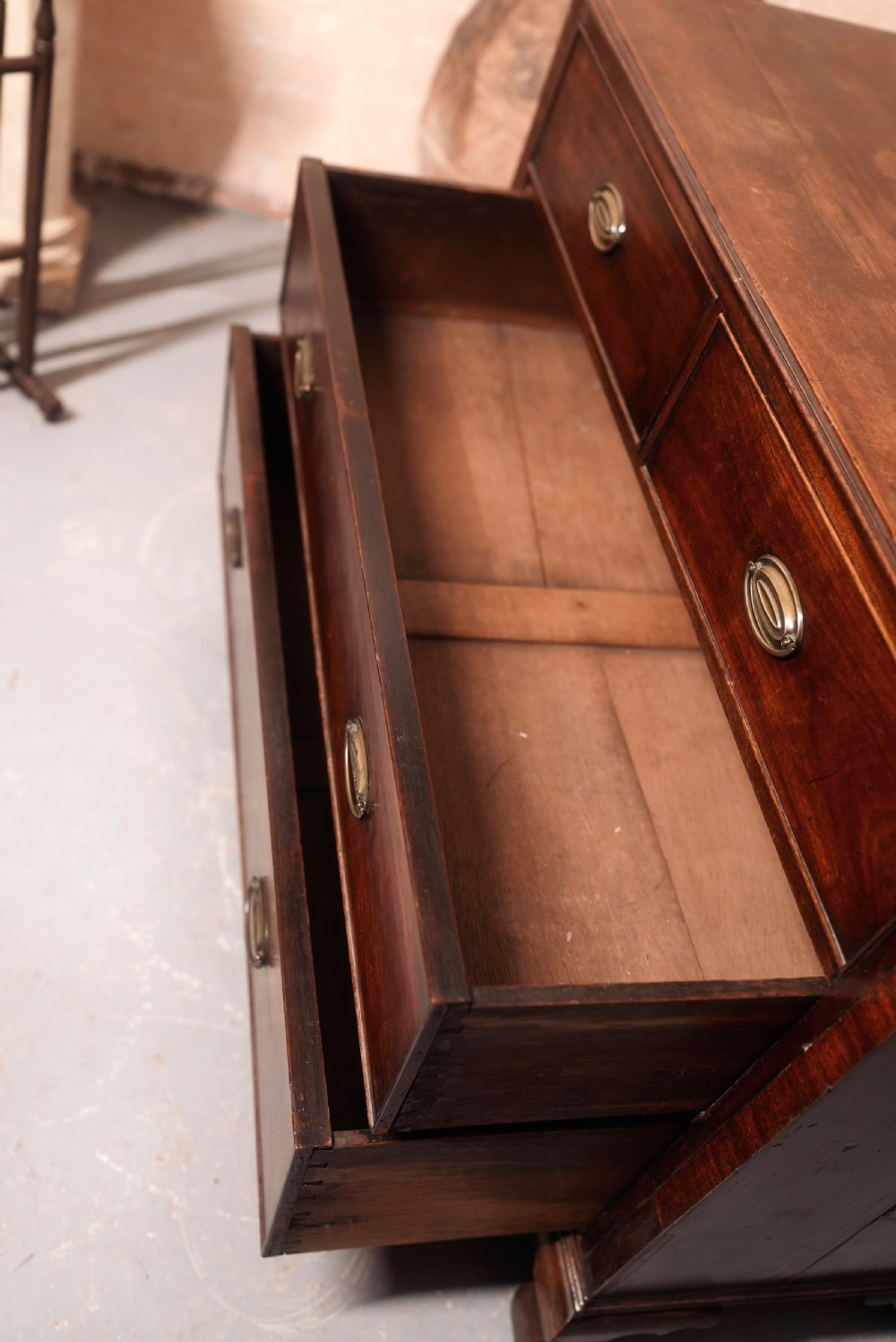 An 18th-century Georgian mahogany chest of drawers featuring two short over two long drawers, oval brass handles, and bracket feet. View IX