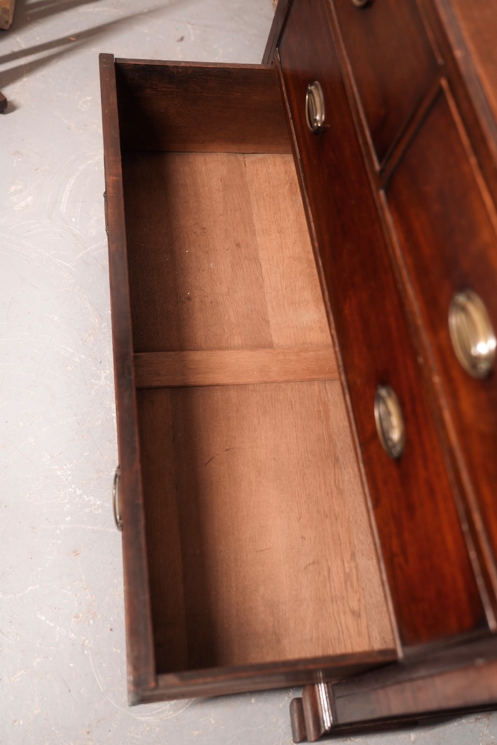 An 18th-century Georgian mahogany chest of drawers featuring two short over two long drawers, oval brass handles, and bracket feet. View X