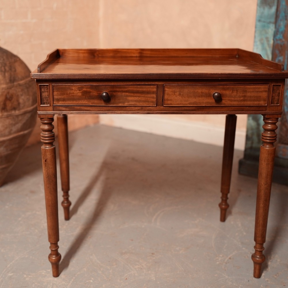 A Georgian mahogany writing table featuring a low gallery rim, two frieze drawers with turned wooden knobs, and slender turned legs. View III