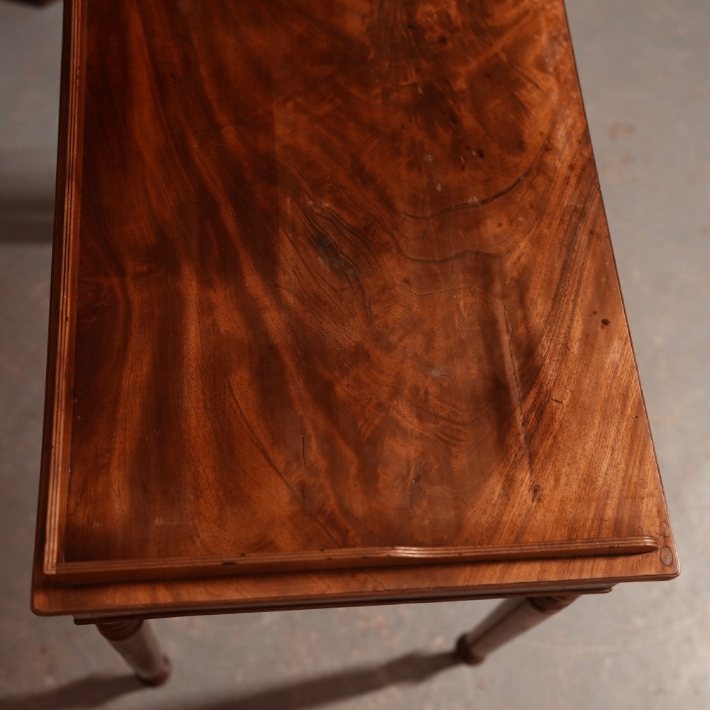 A Georgian mahogany writing table featuring a low gallery rim, two frieze drawers with turned wooden knobs, and slender turned legs. View VII