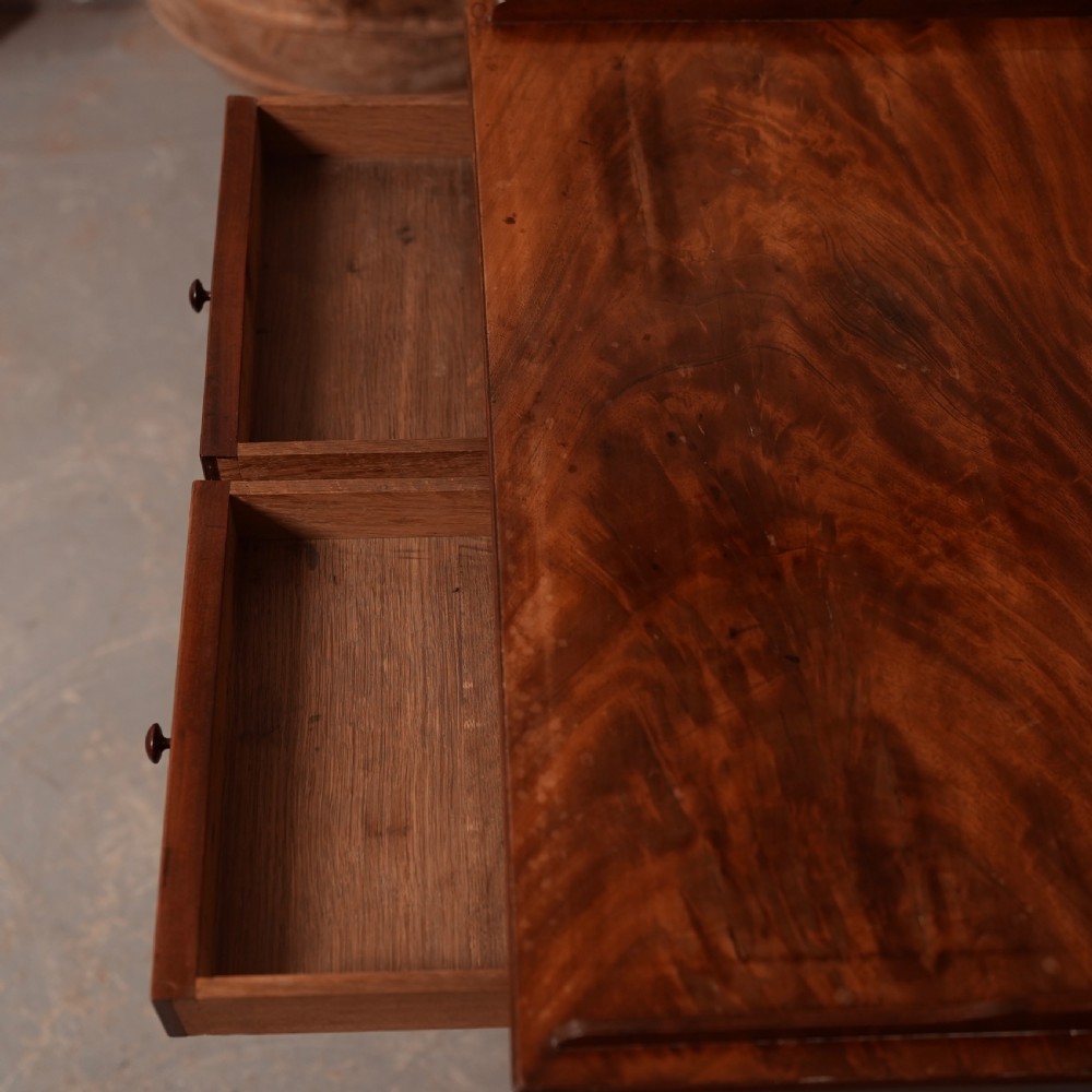 A Georgian mahogany writing table featuring a low gallery rim, two frieze drawers with turned wooden knobs, and slender turned legs. View IX